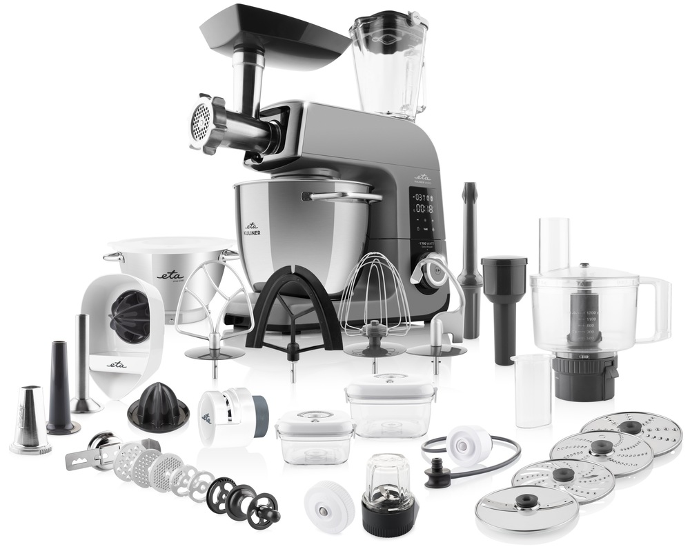 Kuchyňský robot ETA Gratus Kuliner II Vario v šedé barvě s kompletním bohatým příslušenstvím na bílém pozadí. Součástí balení jsou dvě nerezové mísy, mlýnek na maso, skleněný mixér, food processor se strouhacími disky, vakuovací boxy, lis na citrusy, brousek na nože a sada míchacích a šlehacích metel