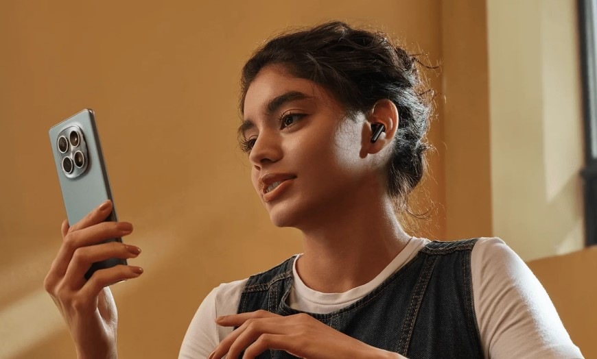 Sluchátka Xiaomi REDMI Buds 8 Active modrá Žena sledující obsah v mobilu se sluchátky REDMI Buds 8 Active