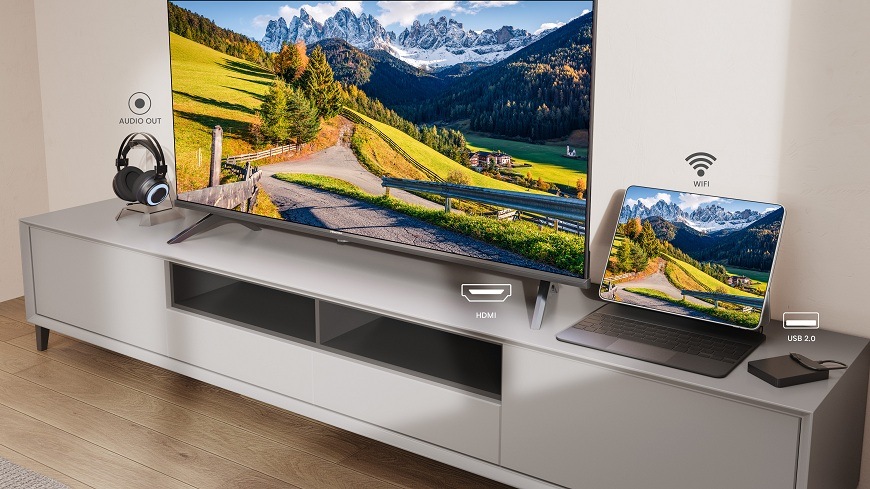 na skříňce se nachází Televize Hisense 40A4S a vedle ní notebook a sluchátka