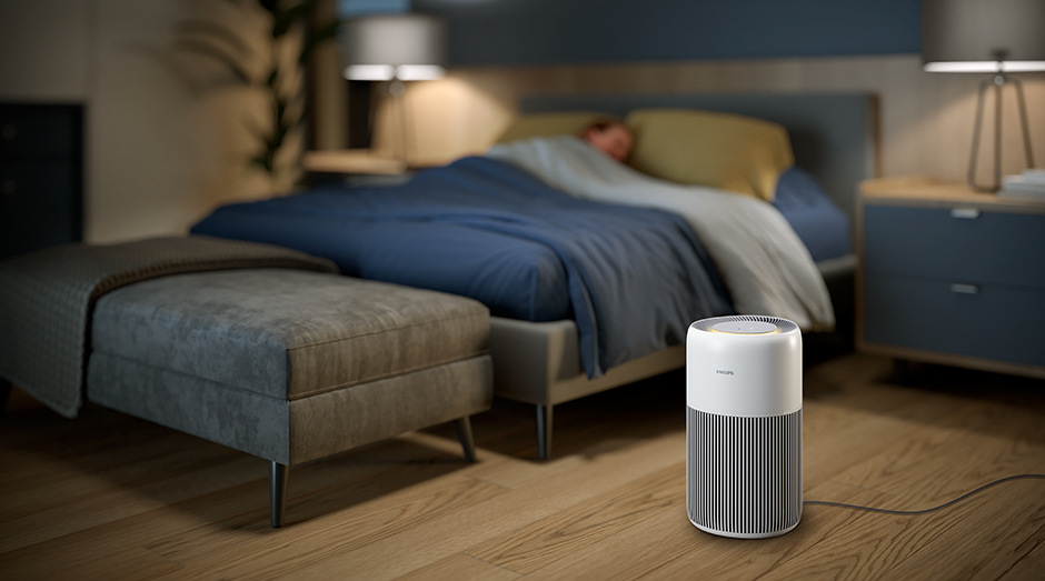 Čistička vzduchu Philips AC2220/10 2000 Series stojící v ložnici vedle postele se spící ženou