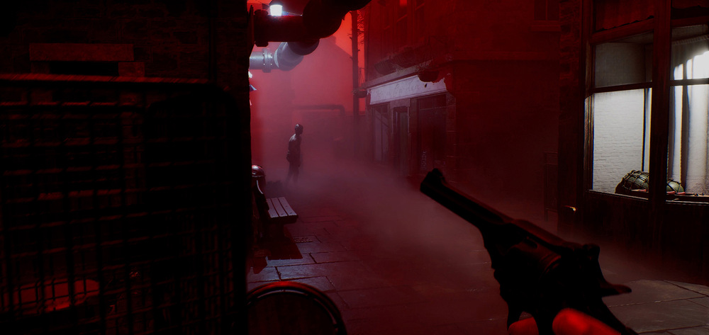 Záběr ze hry Silent Hill Townfall s ponurou uličkou zahalenou v červeném světle a mlze. V dálce silueta osoby s rukou držící revolver v popředí.
