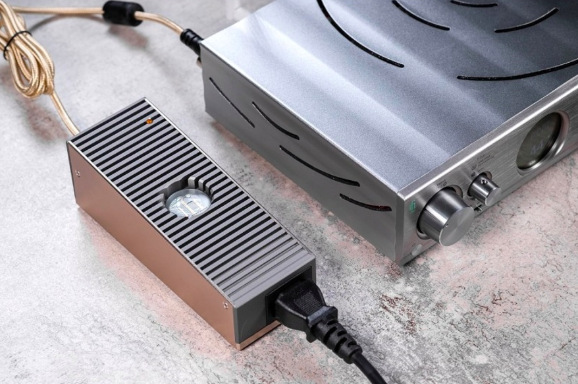 Napájecí adaptér iFi SilentPower iPower Elite 15V při zapojení k audio technice doma na stole