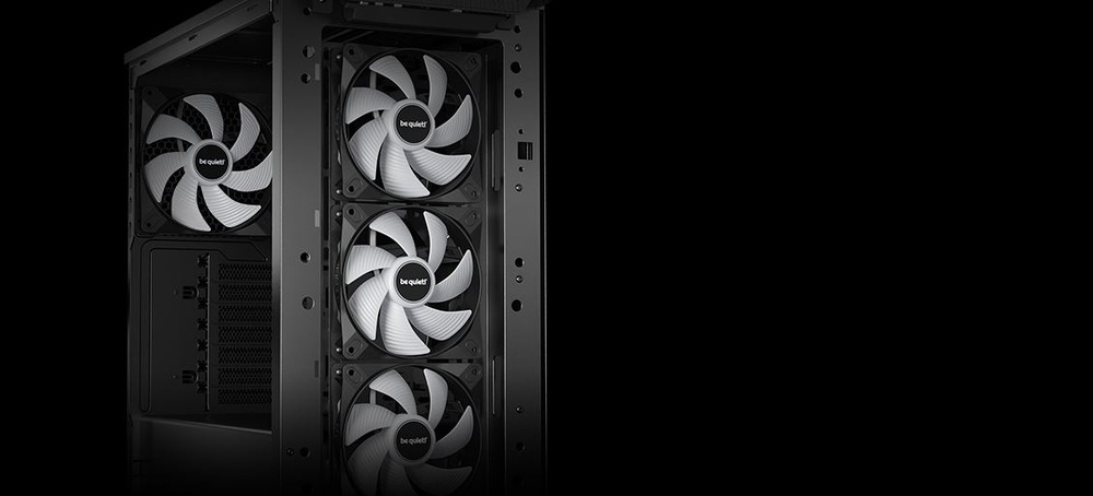 Tři velké počítačové ventilátory s bílými lopatkami a logem s nápisem „be quiet!“ jsou svisle namontovány v ocelové skříni na černém pozadí.