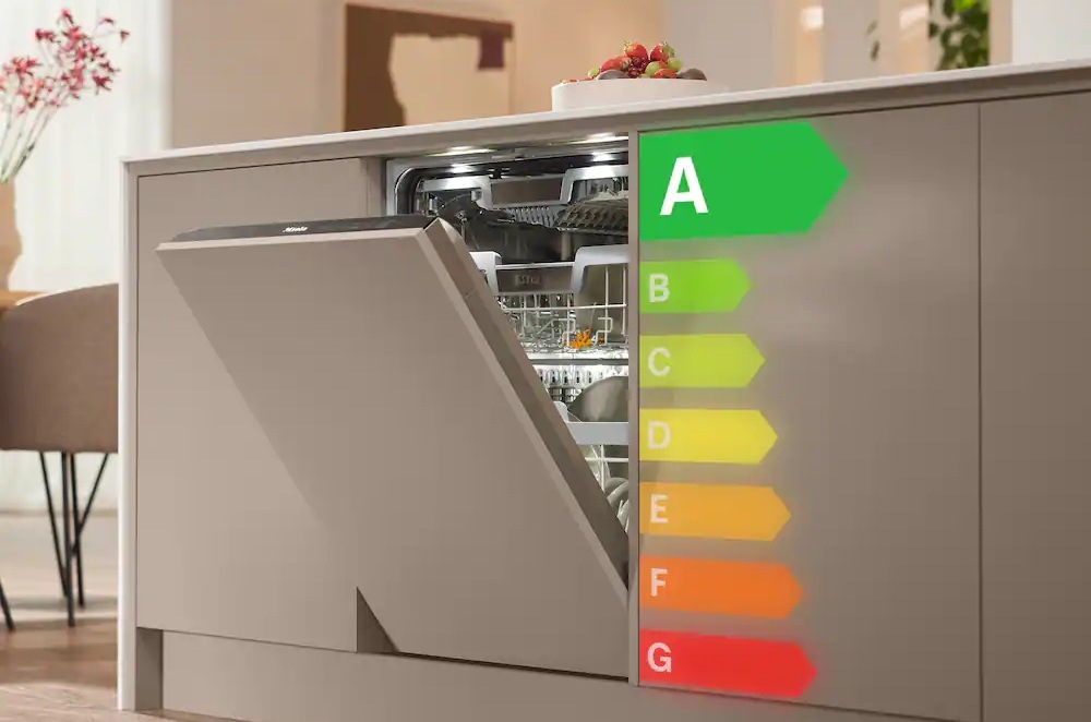 Pootevřená dvířka vestavené myčky Miele zakomponované do linky, vedle dvířek jsou pod sebou grafická znázornění energetických tříd, největší je štítek s písmenem A