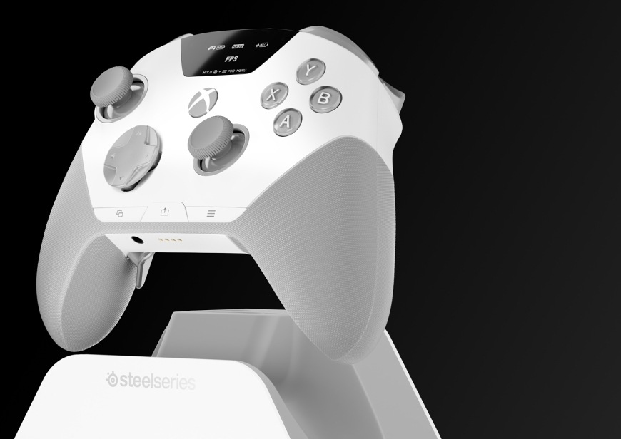Gamepad SteelSeries Aeon Pro černý Bílý gamepad SteelSeries Aeon Pro na dokovací stanici s profilem FPS na displeji.