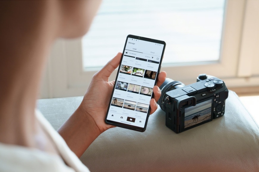 Žena držící smartphone s mobilní aplikací si prohlíží záběry pořízené pomocí Sony Alpha 6700