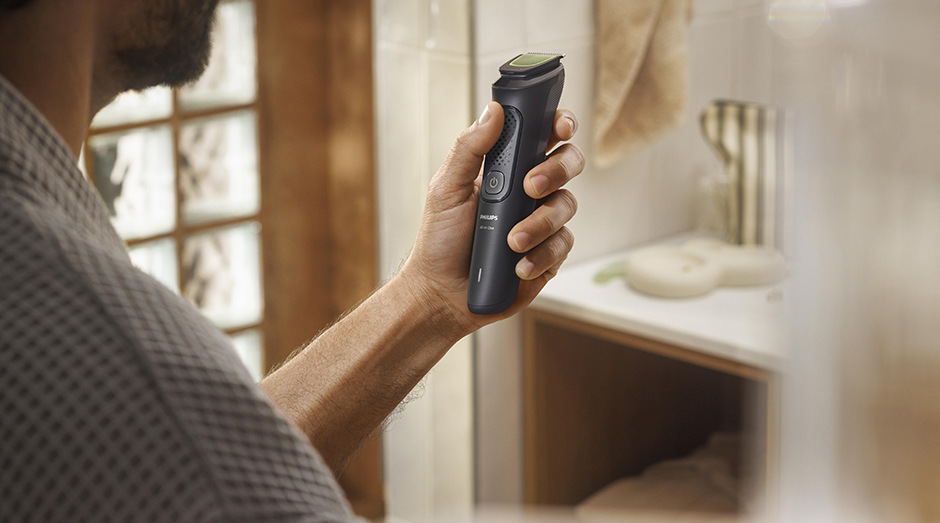 Muž drží v ruce multifunkční zastřihovač Philips MG3920/15