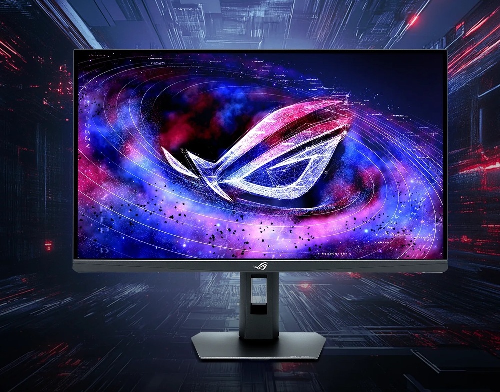Herní monitor Asus ROG Strix XG27AQNGV černý Na obrázku je herní monitor Asus ROG Strix XG27AQNGV 27" v černém provedení. Monitor stojí na výškově nastavitelném stojanu s plochou hranatou základnou a otvorem pro vedení kabelů. Na obrazovce je výrazná vesmírná grafika s velkým svítícím logem ROG v modrých, fialových a růžových odstínech. Pozadí tvoří tmavá futuristická scéna, která zdůrazňuje herní zaměření monitoru a výrazné barevné podání displeje.