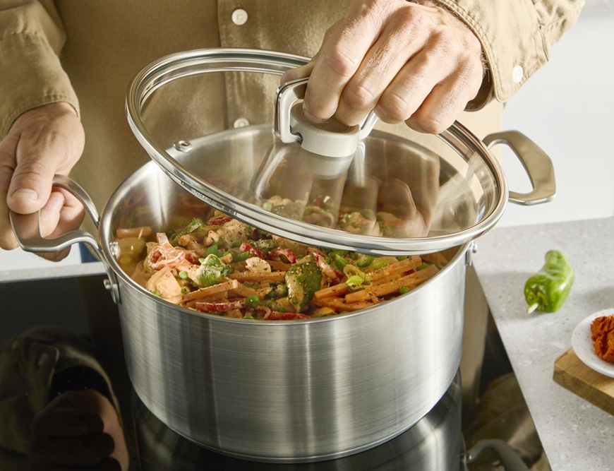 Hrnec s poklicí Tefal Extreme E5294304, 18 cm nerez Muž jednou rukou zvedá pokličku z rendlíku Tefal.
