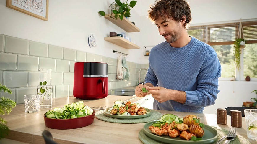 Pán obsluhující horkovzdušnou fritézu Bosch