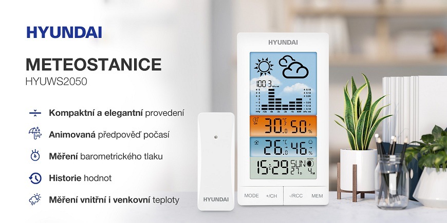Meteorologická stanice Hyundai WS 2050 bílá Meteostanice Hyundai HYWUS2050 s bezdrátovým senzorem, barevným displejem a animovanou předpovědí počasí, zobrazující teplotu, vlhkost, čas a barometrické údaje, umístěná na stole vedle rostliny v moderním interiéru