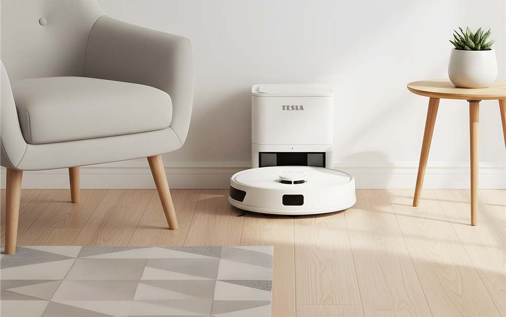 Robotický vysavač Tesla RoboStar iQ660 Plus stojí před stanicí v obývacím pokoji, vlevo je křeslo, vpravo stojí stolek s rostlinou v květináči