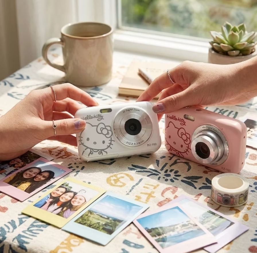 Ruce drží fotoaparáty Yashica x Hello Kitty DZ-100