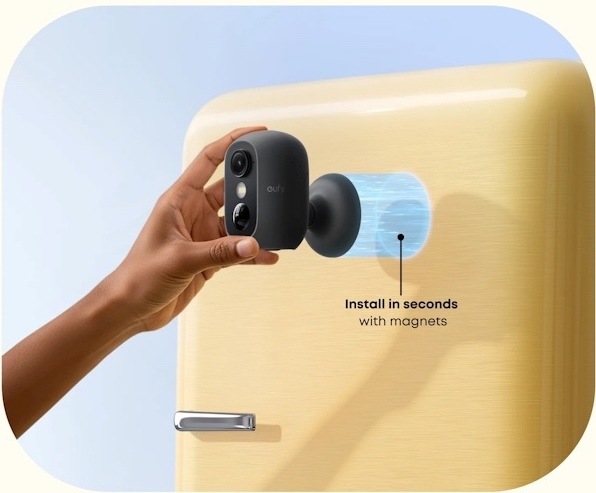 IP kamera Anker eufy C35, 1080p černá Na obrázku je ukázka instalace IP kamery Anker eufy C35 pomocí magnetického držáku. Černá kompaktní kamera se zaobleným tělem je přikládána rukou k držáku na světlých dveřích nebo stěně. Vedle držáku je zvýrazněná modrá plocha znázorňující magnetické uchycení. Text na obrázku upozorňuje, že instalace pomocí magnetů zabere jen několik sekund.