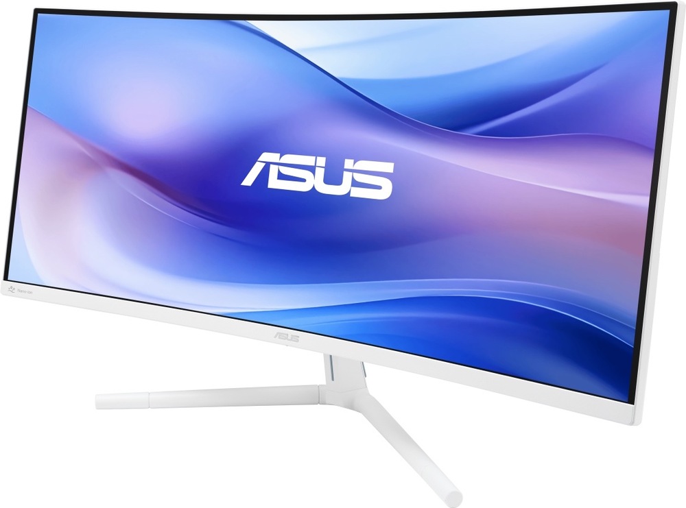 Na obrázku je monitor Asus VU34WCIP-W 34" v bílém provedení z předního šikmého pohledu. Má širokoúhlou prohnutou obrazovku, tenké černé rámečky a světlou spodní lištu s logem Asus uprostřed. Monitor stojí na bílém tříramenném stojanu s dlouhými štíhlými nohami. Celkově působí moderně, elegantně a vhodně pro pracovní i domácí prostředí.