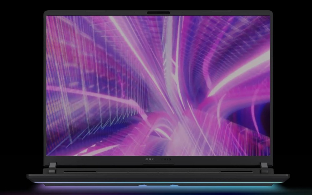Notebook s výrazným abstraktním digitálním designem v růžové a fialové barvě na obrazovce před tmavým pozadím.