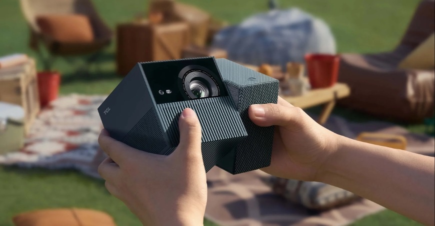 Ruce držící projektor TCL PlayCube s otočnou konstrukcí