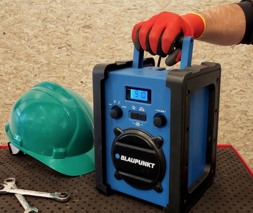 Radiopřijímač Blaupunkt PP30BT JOBSITE černý/modrý Ruka svírá madlo rádia Blaupunkt PP30BT JOBSITE v pracovním prostředí
