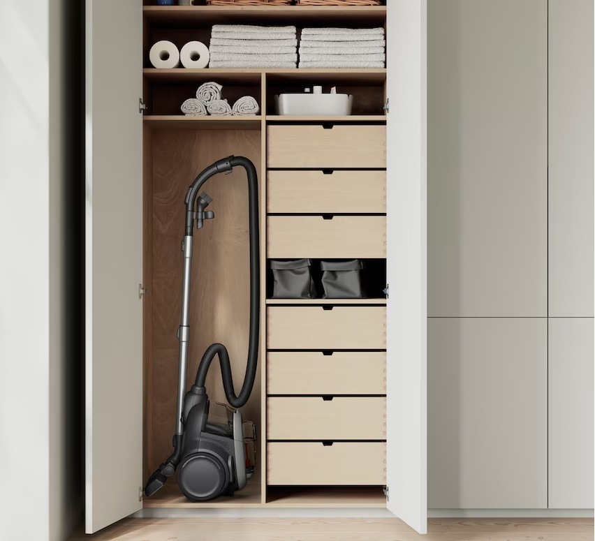 Vysavač Electrolux EL61A4UG série 600 Animal ve svislé poloze v otevřené skříni. Kolem jsou šuplíky a police.