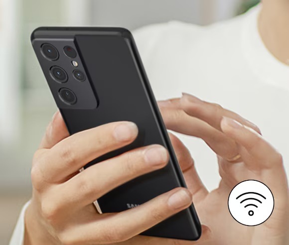 Americká lednice Samsung RF24BB620EB1EO černá Ruce drží mobilní telefon, v pravém dolním rohu je symbol Wi-Fi
