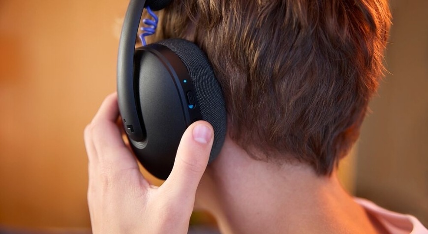 Zadní pohled na hráče, který při hraní ovládá náušník herního headsetu Logitech G325 LIGHTSPEED Wireless