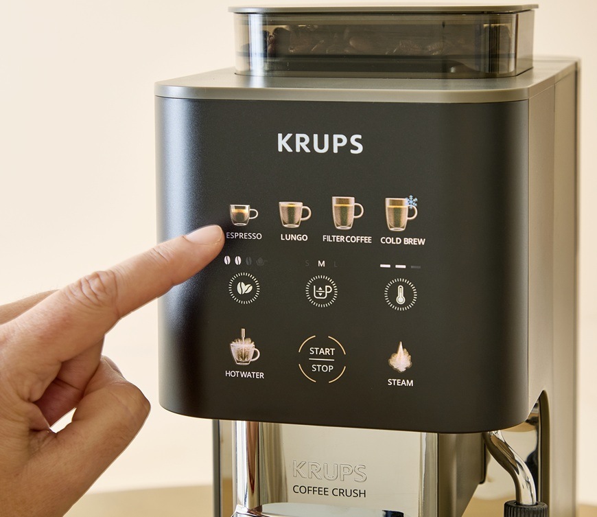 Detailní záběr na přehledný displej na kávovaru Krups SA403BE0. Žena si chce připravit espresso ve velikosti M.
