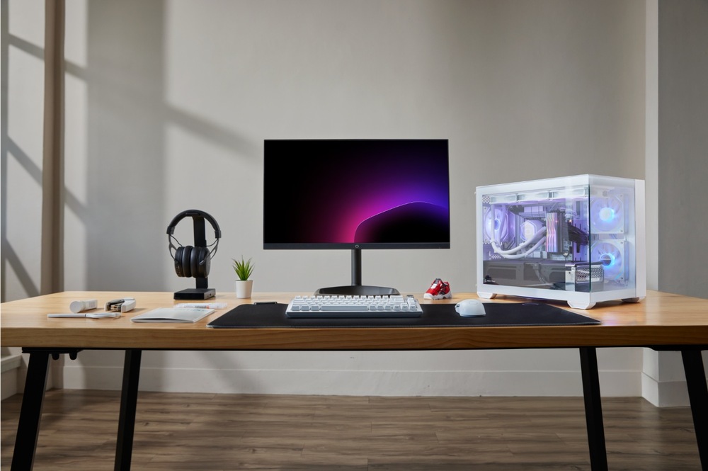 Case Cooler Master Elite 481 Wood ARGB bílá Moderní počítačová sestava na dřevěném stole obsahuje elegantní monitor s fialovým gradientním pozadím, bílý herní počítač, klávesnici, myš, sluchátka a malou rostlinu.