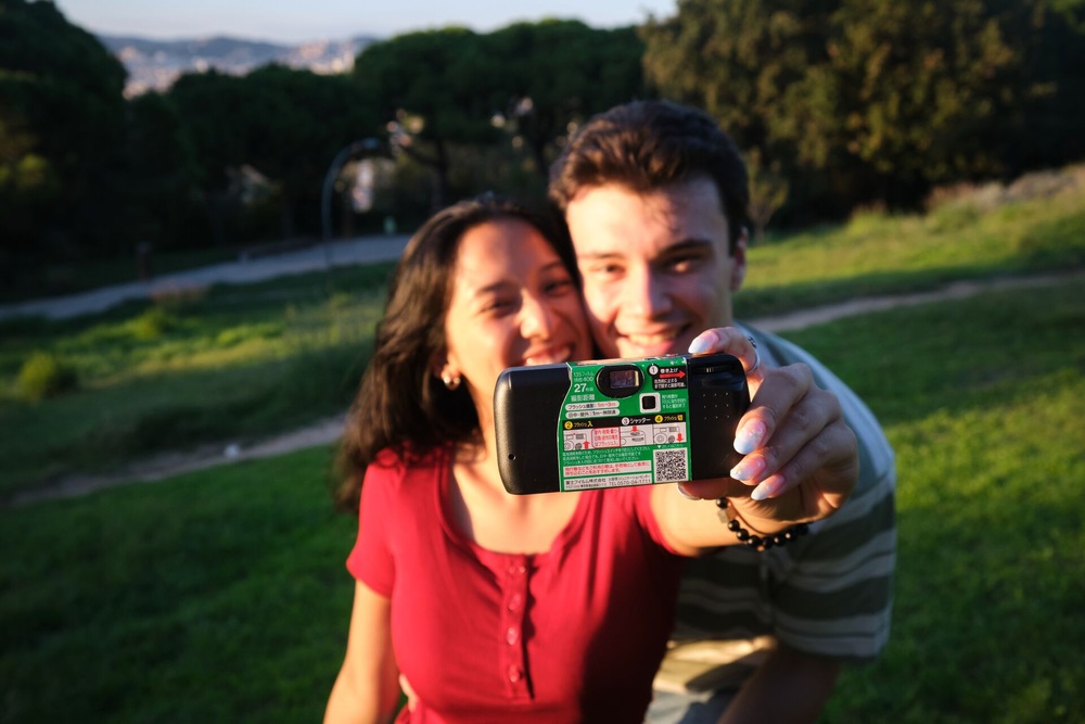 Žena si fotí s mužem selfie jednorázovým fotoaparátem Fujifilm QuickSnap Flash 400/27