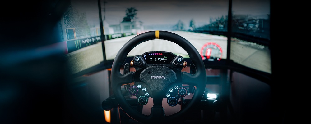 Volant Moza Racing CS Pro hliník Sestava závodního simulátoru s volantem výrobce Moza Racing uprostřed, který zobrazuje digitální ovládací prvky. V pozadí je rozmazaný záběr závodní tratě.