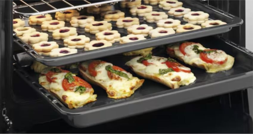 Sklokeramický sporák Electrolux LKR540066W bílý Plechy na více úrovních v troubě Electrolux. Na horním plechu je linecké cukroví. Na spodním plechu je zapékané pečivo.