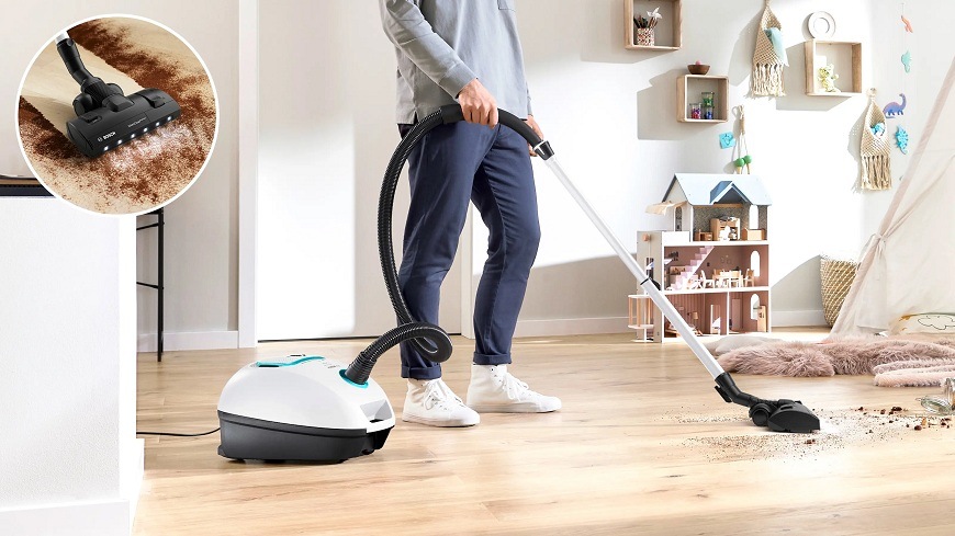 Podlahový vysavač Bosch ProSilence BGL41SIL0L bílý Muž vysávající s vysavačem Bosch BGL41HYG0L světlý světlou podlahu v obývacím pokoji