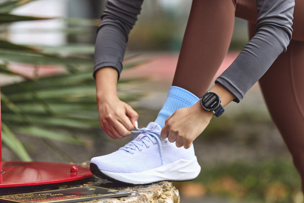 Chytré hodinky Amazfit Active 3 Premium modré Žena si zavazuje běžeckou botu a na zápěstí má hodinky Amazfit Active 3 Premium