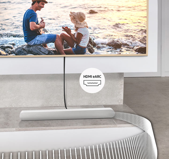 Soundbar Samsung HW-S61D bílý Soundbar Samsung HW-S61D leží pod televizí se záběrem dvou lidí u moře, soundbar a televize jsou propojené kabelem, vedle nějž je ikona HDMI eARC, ze soundbaru vycházejí bílé čáry znázorňující zvuk