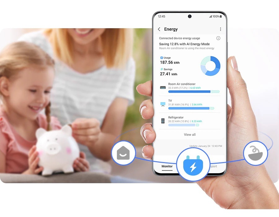 Ruka drží mobilní telefon s aplikací SmartThings Energy, na pozadí je žena s dítětem a kasičkou ve tvaru prasátka