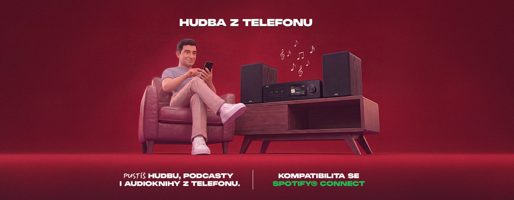 Muž v křesle ovládá chytrým telefonem mikrosystém JVC MX-E455. Banner s textem „Hudba z telefonu“ představuje přehrávání hudby, podcastů i audioknih z mobilu a kompatibilitu se Spotify® Connect.