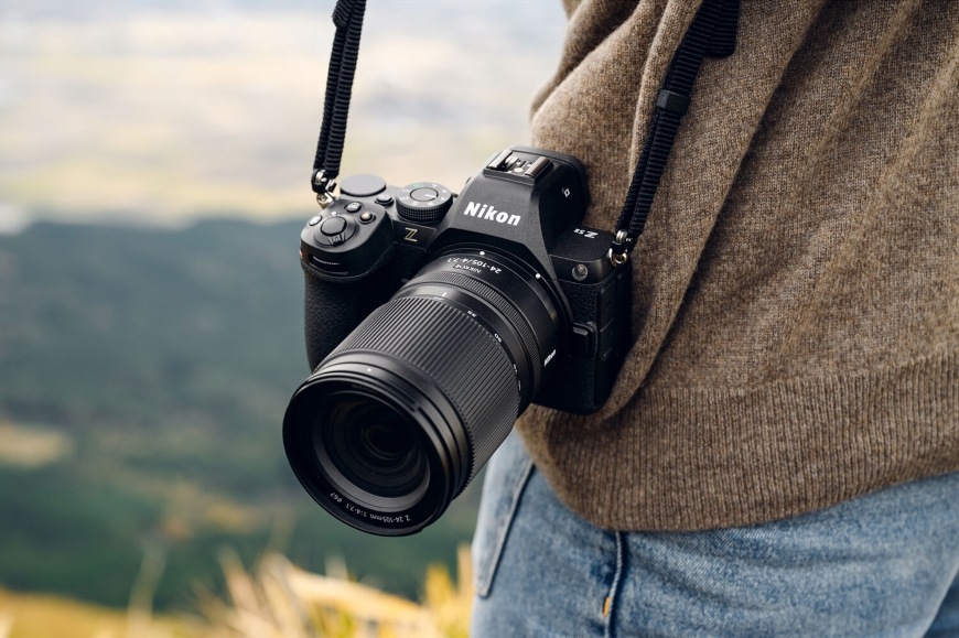 Detail fotoaparátu Nikon Z upevněném na ramenním popruhu s lehkým a kompaktním objektivem NIKKOR Z 24–105 mm f/4–7.1