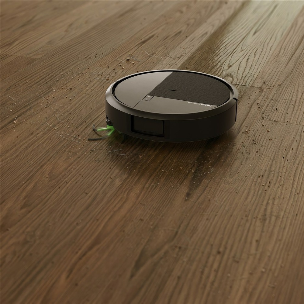Robot Roomba uklízí smetí na podlaze.
