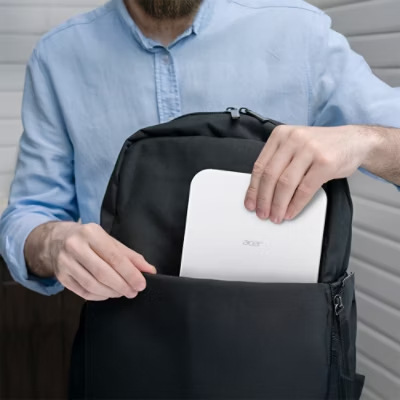Muž vkládá přenosný projektor Acer PD1520s do batohu