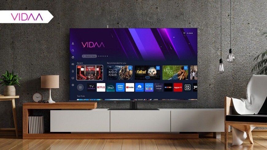 Televize JVC LT-65VDQ9435 Televize JVC na televizním stolku v moderním interiéru obývacího pokoje se zobrazením operačního systému VIDAA a staženými aplikacemi