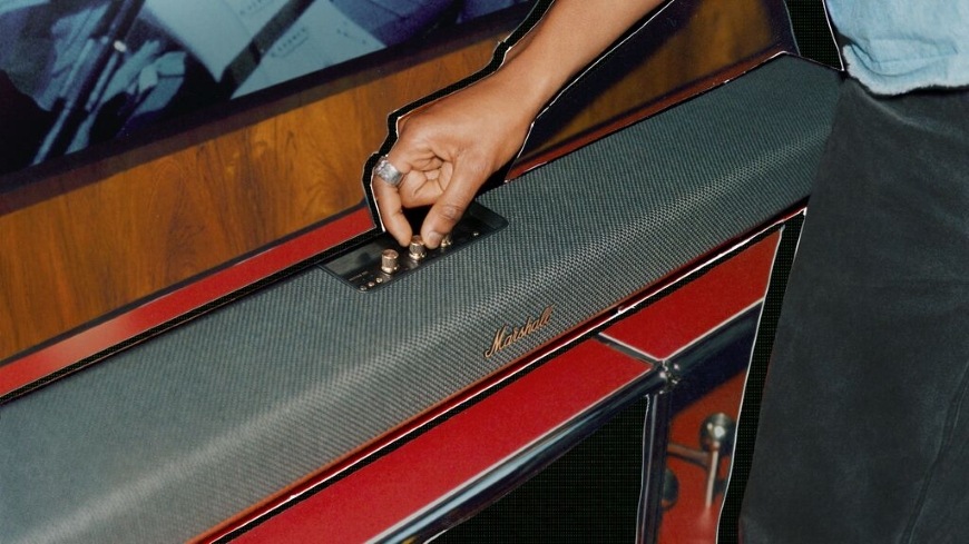 Detail soundbaru Marshall Heston 120 a ruky ovládající otočné knoflíky