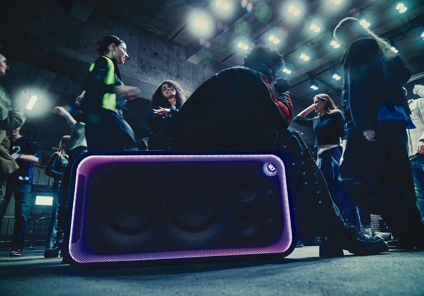 Party reproduktor Sony ULT TOWER MAX ve vodorovné poloze s barevným osvětlením během hudební párty