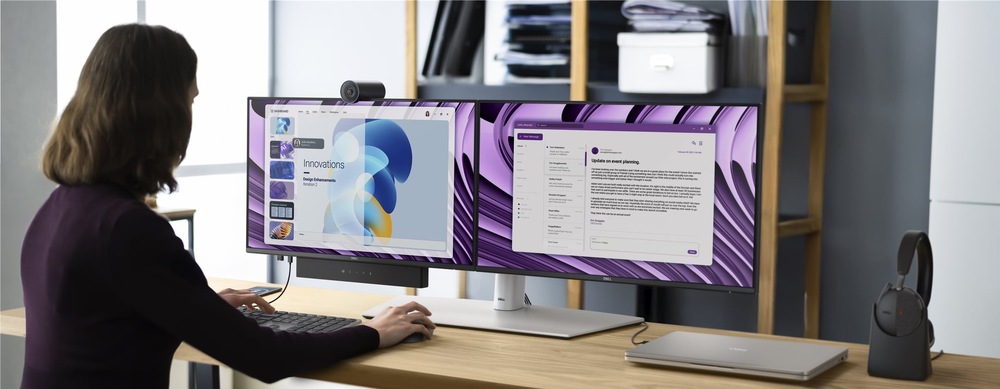 Monitor Dell Pro P 24 P2426HE šedý Dva šedé monitory Dell Pro P 24 P2426HE umístěné vedle sebe na pracovním stole. Sestavu doplňuje webkamera, soundbar, klávesnice, myš, notebook a náhlavní souprava.