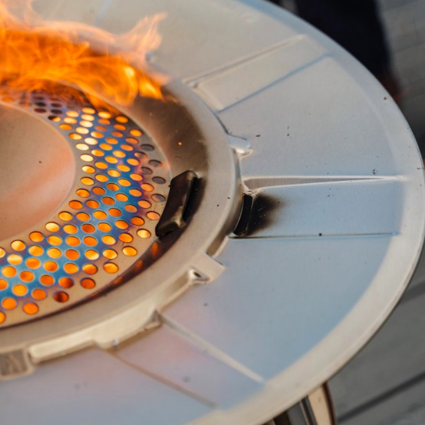 Detail nerezového rozptylového disku deflektoru Solo Stove Yukon během hoření ohně