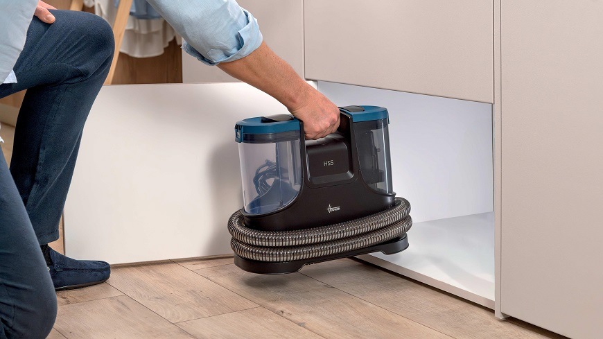 Tepovač koberců Hoover HS500 011 černý/modrý HS500 011 osoba zvedá tepovač za vestavěné madlo