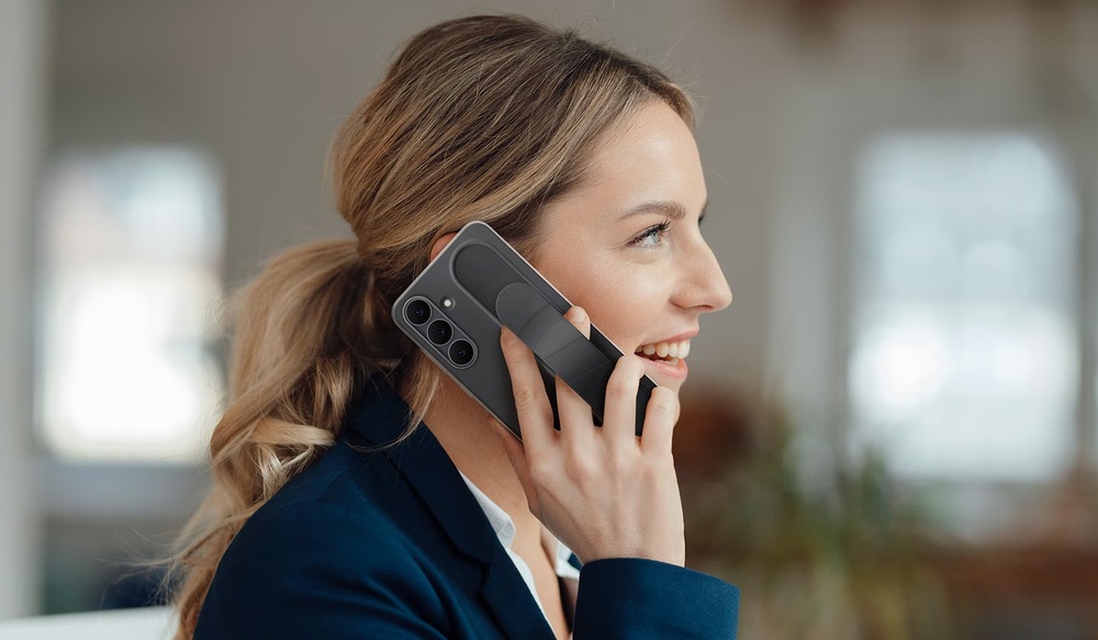 Kryt na mobil Samsung Standing Grip na Galaxy S25 FE černý Kryt na mobilní telefon Samsung Galaxy S25 FE - žena držící telefon v krytu Samsung Standinf Grip v černém provedení