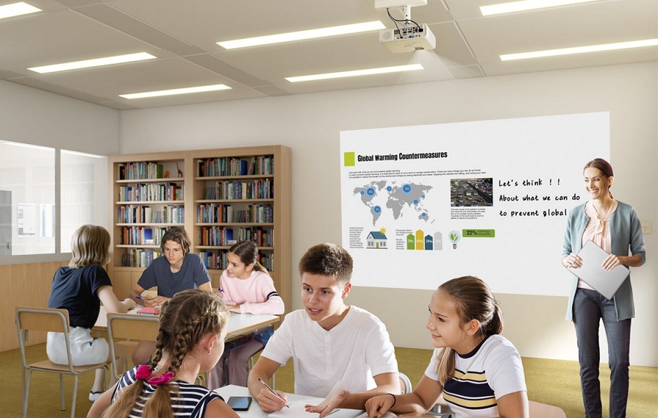 Žena se studenty v učebně prezentuje na projektoru Epson EB-L260F