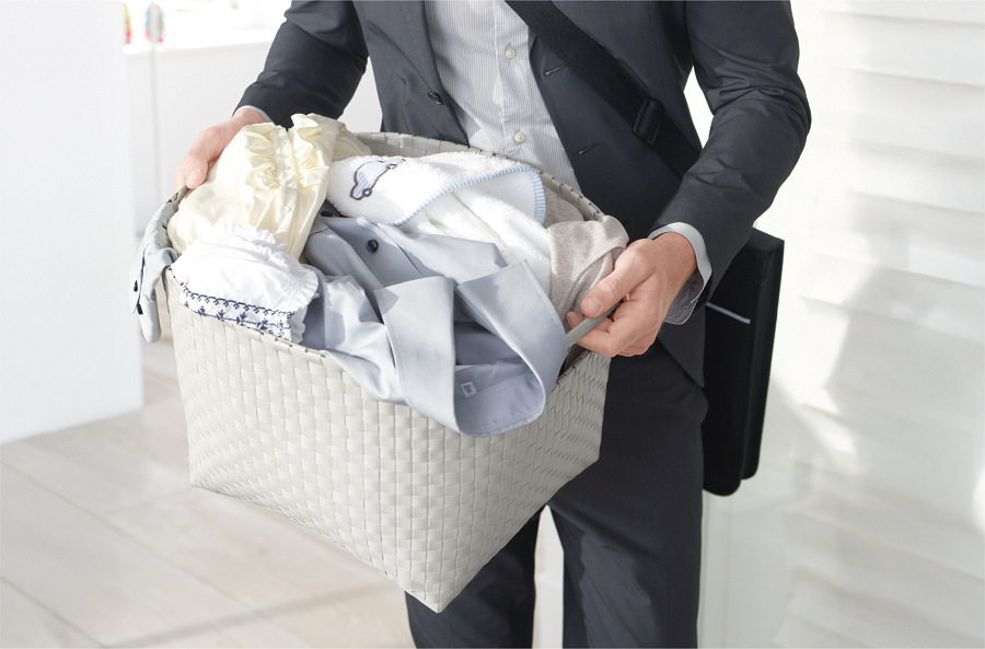 Pračka/sušička Whirlpool WPD 0736W ADS EE, muž v obleku a notebookem na rameni drží koš plný prádla, hlavně košil