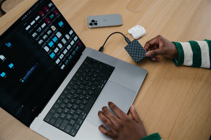 Osoba pracující na notebooku se soubory uloženými na SSD Verbatim Store 'n' Go Mini Diamond