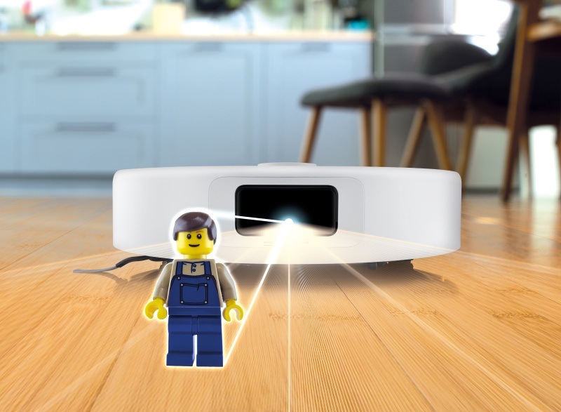 Robotický vysavač ETA Master Aqua Pro při práci detekující lego figurku na podlaze pomocí 3D scanu