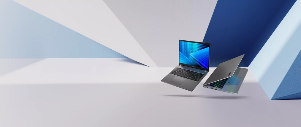 Notebook Acer TravelMate P2 (TMP216-71-G3-TCO-53AR) šedý Dva elegantní notebooky se vznášejí v moderním geometrickém prostředí v chladných modrých a bílých tónech, které vyjadřují inovativnost a sofistikovanost.